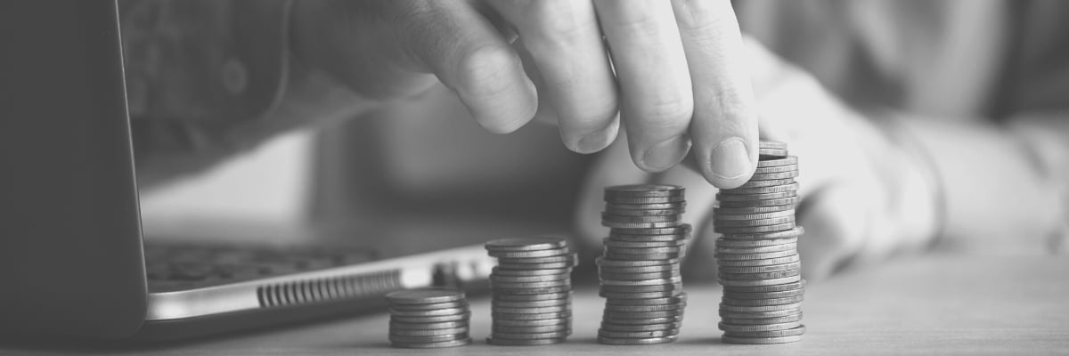 Image of a hand stacking coins at increasing heights to illustrate the NY Minimum Wage Increases included in the 2024 budget